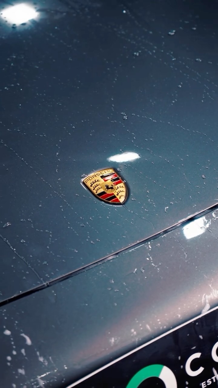 Emblema de Porsche com gotas de água na pintura após detalhamento automotivo em Passo Fundo